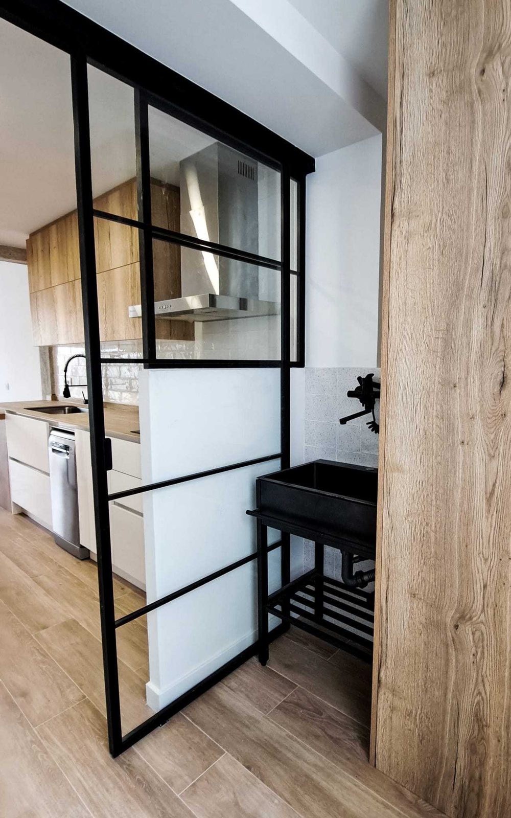 Salón con cocina abierta tras la reforma integral de un piso de 90 m² en Vista Alegre, Madrid